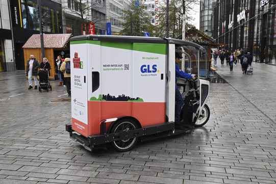 An electric parcel delivery car in a pedestrian area