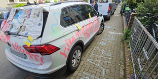 Ein auf dem Gehweg parkendes Auto mit Schmierereien
