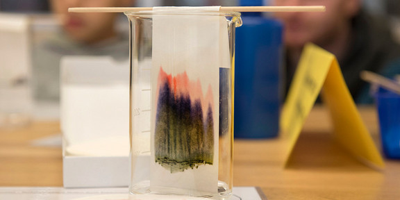 Messglas mit Filter Ein Messglas in dem ein dunkel gefärbter Filter hängt.